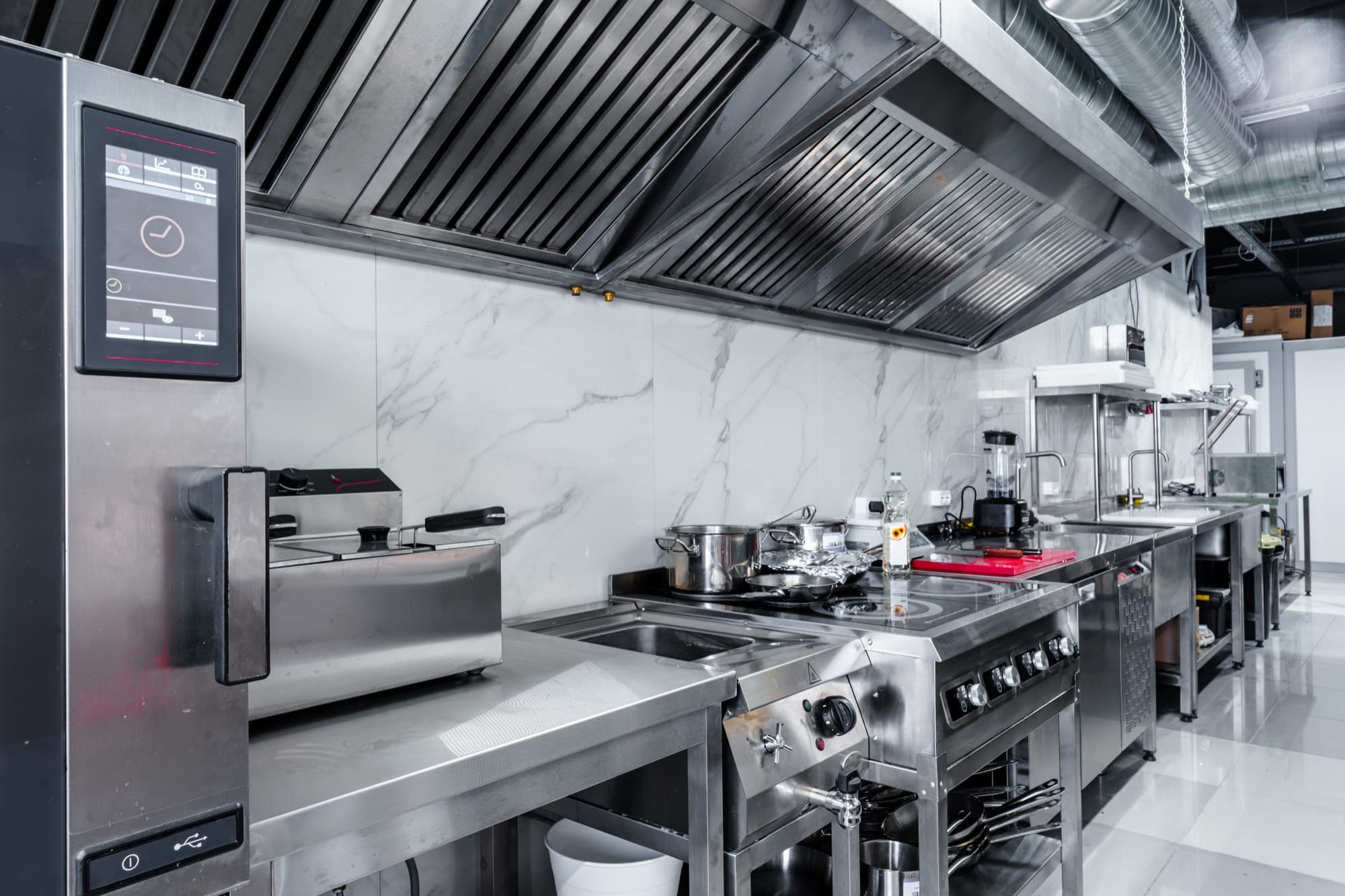 Stainless steel exhaust hoods over a professional cooking line