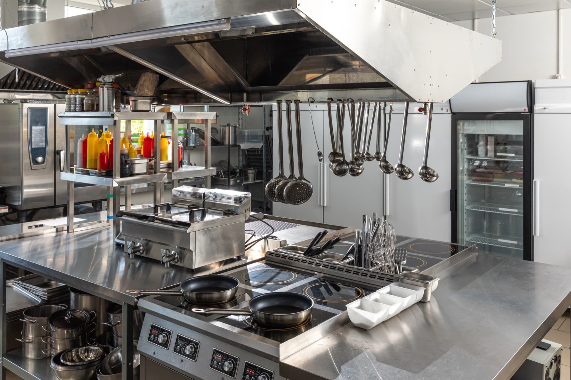 Empty professional kitchen with stainless steel equipment laid out